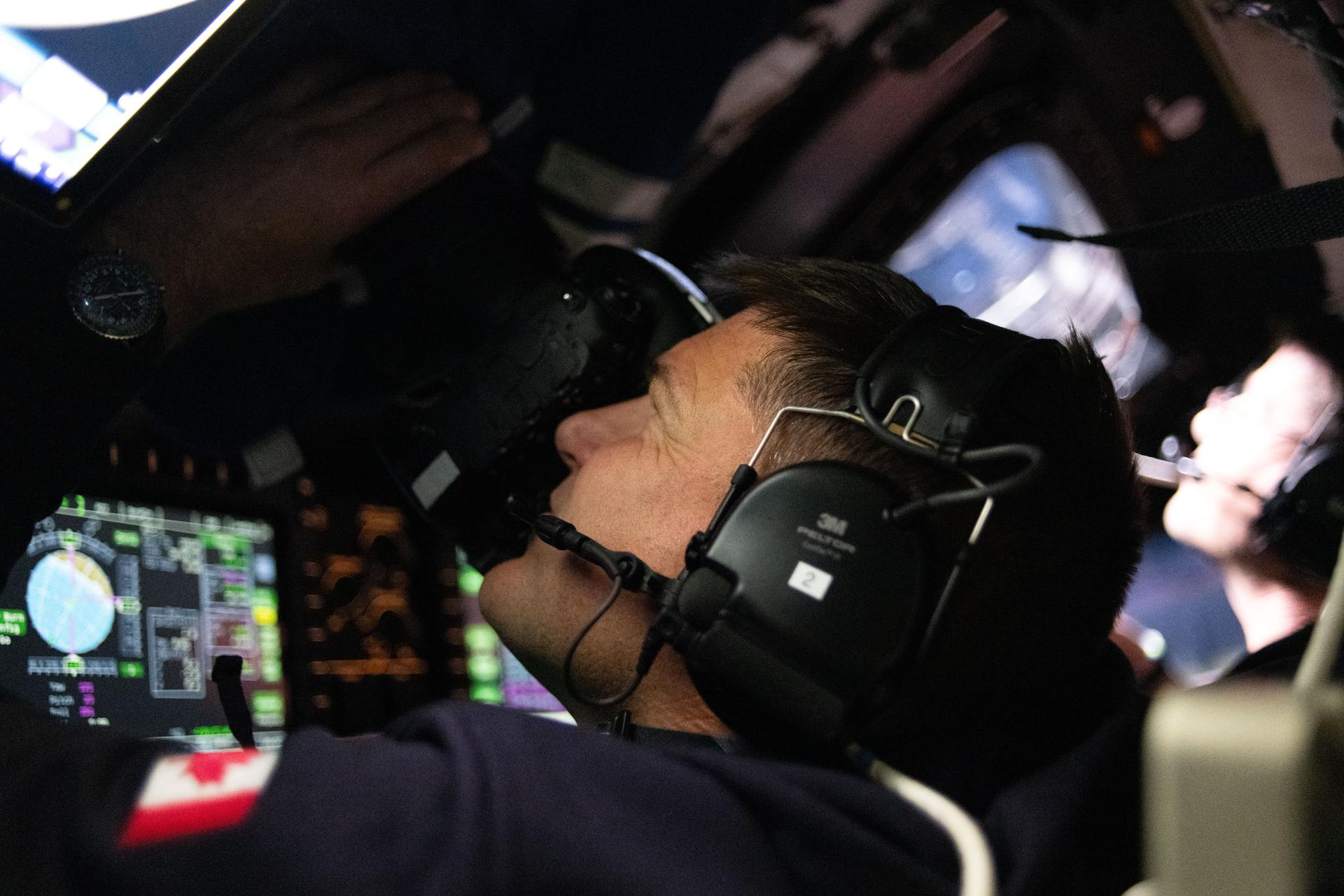 CSA (Canadian Space Agency) astronaut and Artemis II Mission Specialist Jeremy Hansen is seen taking images through the Orion spacecraft window early in the Artemis II lunar flyby.
